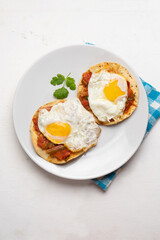 Fried eggs with sauce and tortilla called rancheros for  breakfast on white background. Mexican food