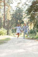 Fototapeta premium young couple in love having fun and enjoying the beautiful summer nature. woman and man, wearing in denim outfit are having date outdoors in the park. Romantic relationship. valentines day