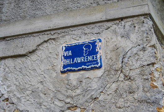 Blue street sign meaning "D.H. Lawrence street" with a silhouette of the famous English writer who lived in Spotorno, Liguria region, Italy