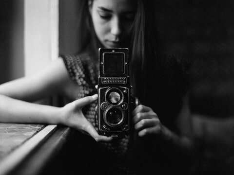 Stylish woman holding retro photo camera