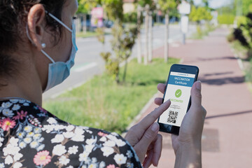 Biology and science. Covid-19.Woman holding smartphone displaying a valid digital vaccination certificate or passport against Coronavirus or Covid-19. Travel, health or surveillance concept.