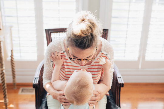 mother leaning over to kiss her baby