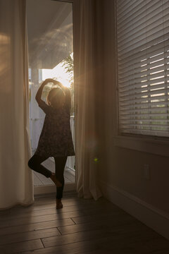 A Child Doing A Pirouette In Front Of A Glass Sliding Door