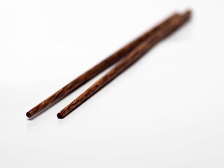 Close up shoot of a pair of wooden chopsticks on a white isolated background