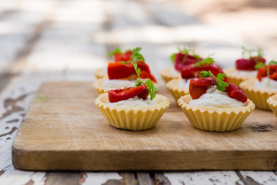 canapes of pastries filled with goat curd and red pepper