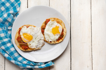Fried eggs with sauce and tortilla called rancheros for  breakfast on white background. Mexican food