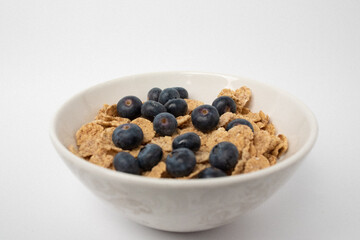 white cup with blueberries and cereals
