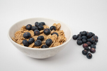 white cup with blueberries and cereals

