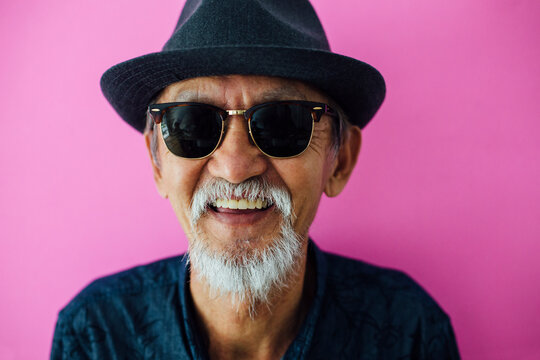 Senior asian man portrait on pink background