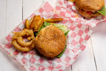 Cheese burger with onion rings and potato fries on white background