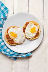 Fried eggs with sauce and tortilla called rancheros for  breakfast on white background. Mexican food