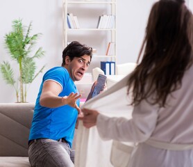 Obraz premium Young wife is trying to seduce husband from watching football an