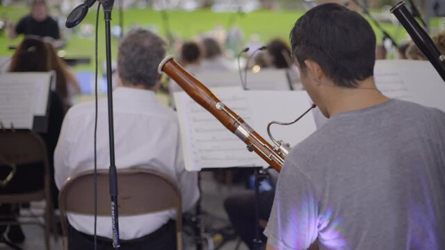 Back View of a Bassoon Player and Orchestra Section Performing in Glen Cove