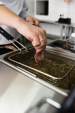 Cook putting food to fryer