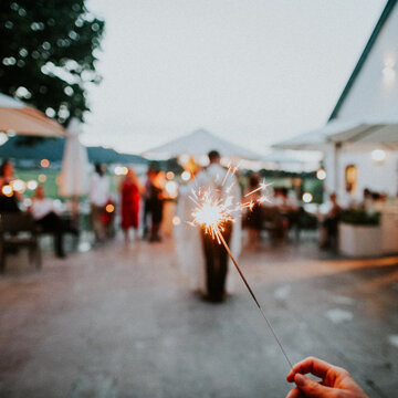 Lit sparkler at outdoor party