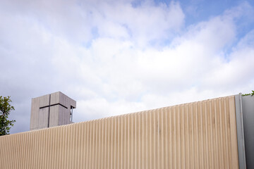 Tower of a modern church with a simple and minimalist design, seen from the outside, with a concrete cross.