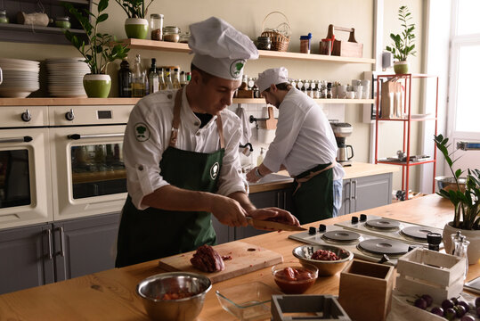 Man slicing meat on restaurant kitchen
