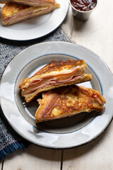 Ham and melted cheese sandwich called Monte Cristo on white background