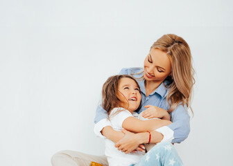 Happy family - mom and daughter playing at home. Family sitting on floor and playing and...