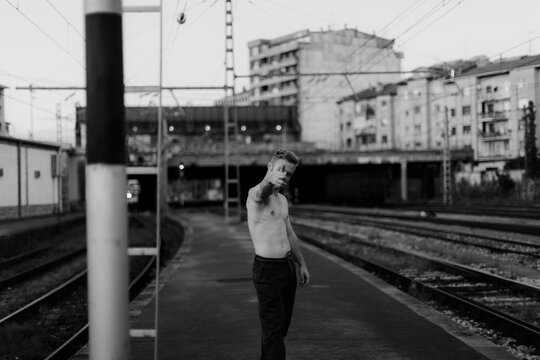 barechest young man on a railway