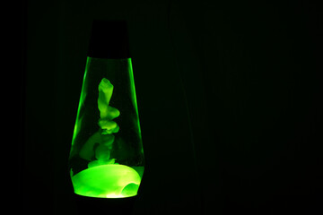 Green lava lamp in a dark room