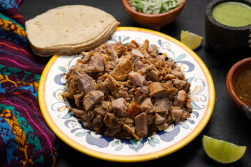 Confit pork called carnitas on dark background. Mexican food