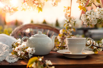 Tea set, cherry blossom branches, wooden table. Outdoor breakfast, picnic, brunch, spring mood. Soft focus