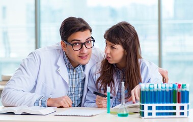 Two chemists working in lab experimenting