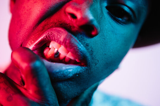 Cool man showing his silver tooth under blue and pink lighting