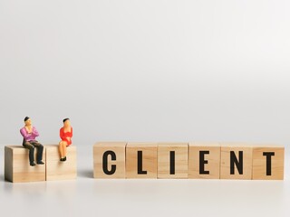 Phrase CLIENT on wooden cubes with people miniature. Business concept.