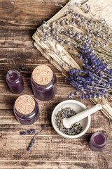 Dried lavender flowers in a in a mortar and pestle with bottle of essential lavender oil or infused water