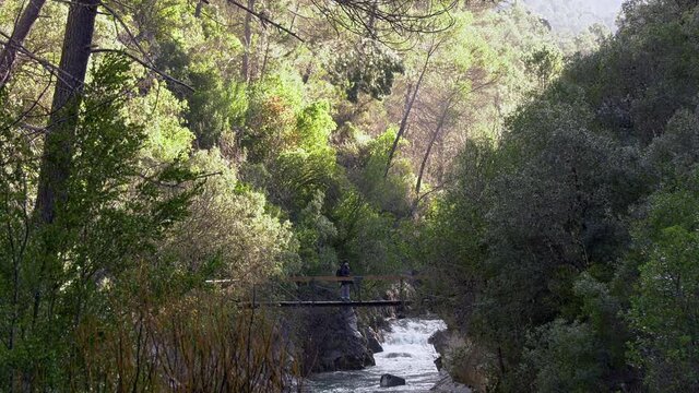 Sierra de Cazorla, Cerrada de El&iacute;as,Brunette girl crossing the river by the bridge
