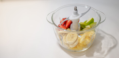 The transparent bowl of mix fruit and the knife inside preparing for made smoothies mix fruit, good for health and diets.