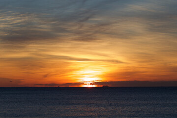 Spring Sunrise over the Pacific ocean in Chiba Japan. An amazing orange glow with wispy clouds makes this a beautiful background image.