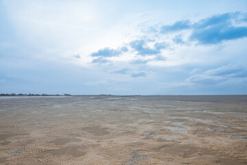 Fototapeta na wymiar North Sea in winter at low tide. Beautiful clouds and ice on the North Sea in East Frisia 