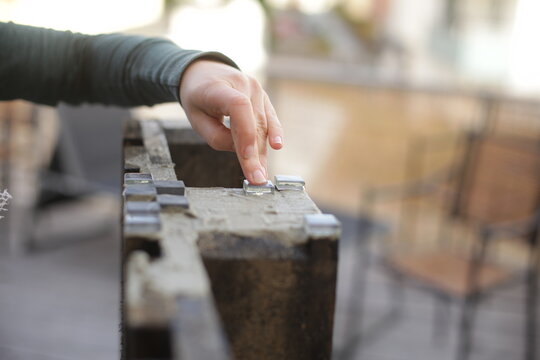 Crop woman arranging mosaic on fence