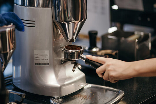 Person preparing coffee using machine