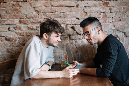 Men browsing smartphone in bar