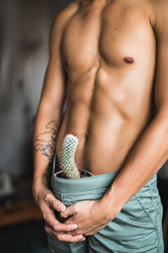 Well built handsome man topless with a cactus in his pants