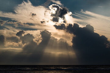 Sunlight breaking through the clouds over the ocean