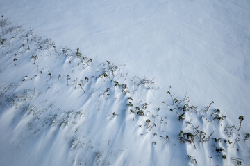 Top and close up view at thick layer of snow cover grass ground field.