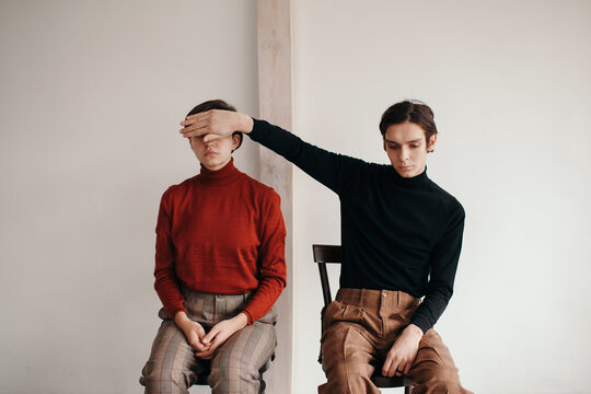 Handsome sad man covering eyes of model