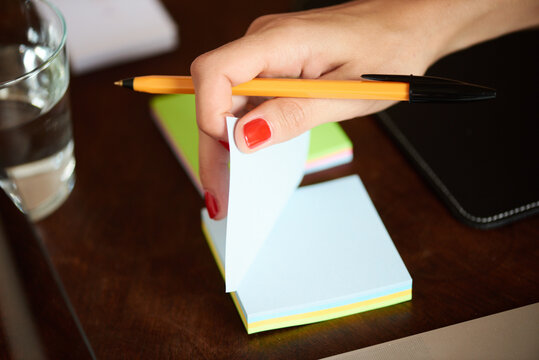 Hand taking sticky note