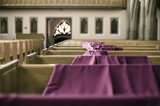 purple linen draped across numerous church pews in old church
