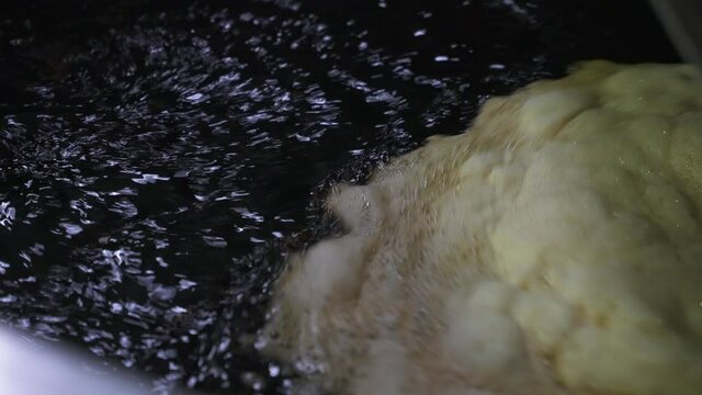 Close up shot of soy sauce in processing tank, Septic waste water with foam in process to be reused in heavy factory industry. Waste management industrial concept.