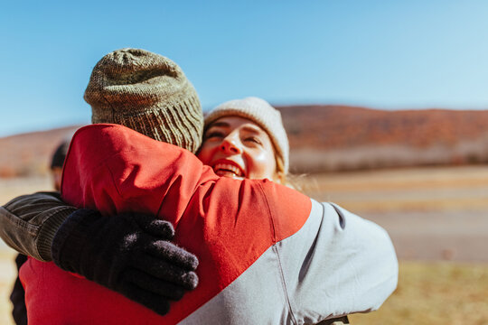 Friends hugging on an airfield after flying glider planes