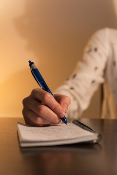 Crop woman writing in notepad