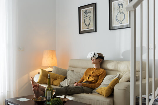 Model posing in VR glasses on sofa