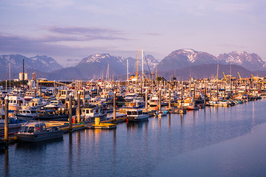Sunset at marina with boats docked on water in Alaska
