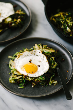 High angled view of whole30 fried egg over Brussels sprout hash